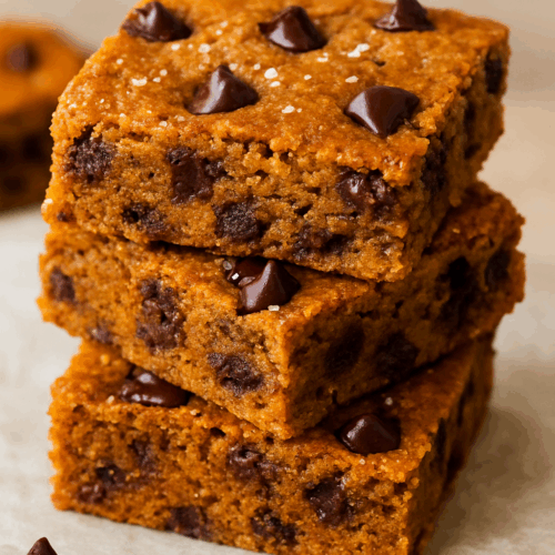 Sliced Chocolate Chip Pumpkin Cheesecake Protein Bars | Healthy Fall Dessert served on a plate, showing the soft pumpkin cheesecake layer and studded chocolate chips.