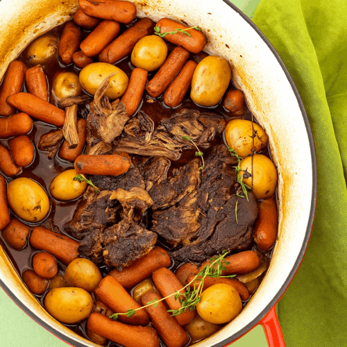 High-protein pot roast with tender beef chunks, carrots, and potatoes in a rich savory broth, served in a rustic bowl, perfect healthy comfort meal