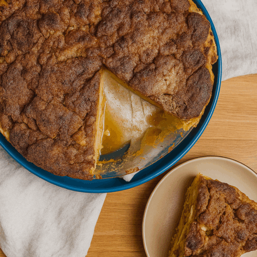 Golden high protein apple pie crumble in a white baking dish, topped with crunchy oat crumble, served warm for a cozy fall dessert