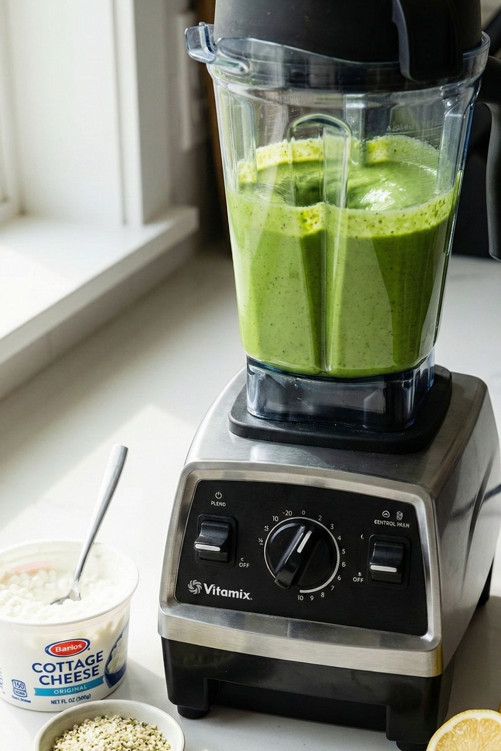 Smooth and creamy bright green salad dressing made with cottage cheese and spinach inside a high-speed blender jar.