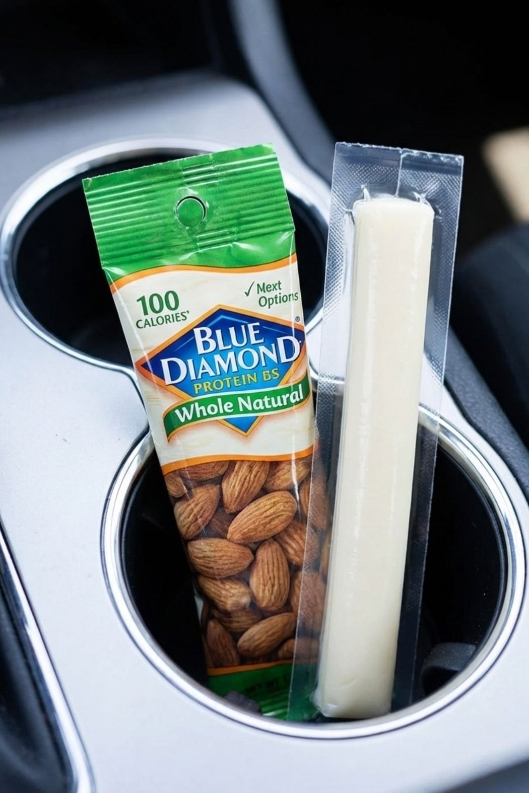 Blue Diamond 100 calorie almond pack and a Frigo cheese stick placed in a car cup holder for healthy portion control.