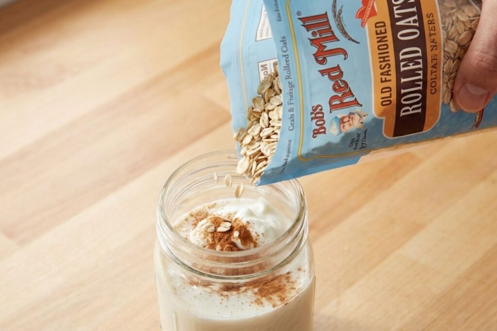 Adding Bob's Red Mill Rolled Oats, non-fat Greek yogurt, and cinnamon to the liquid base to create a fiber-rich and high-protein breakfast blend.