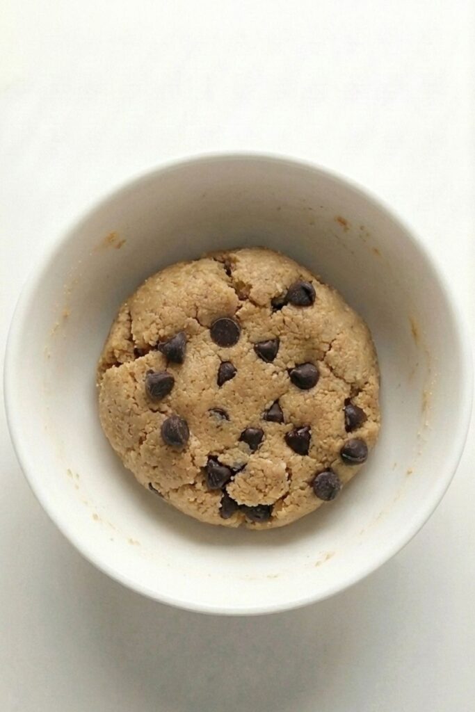 The dough broken open to show chocolate chips evenly distributed inside the mixture.