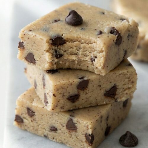 A stack of three fudgy collagen protein bars with chocolate chips, showing the chewy texture of this healthy low sugar snack.